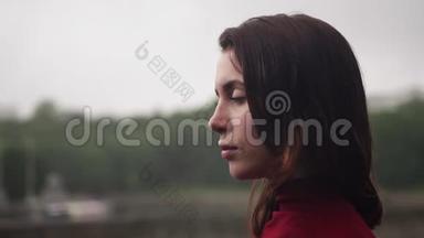 阴晴不定的阴雨天气，头发湿漉漉的年轻悲伤的女人望着远方